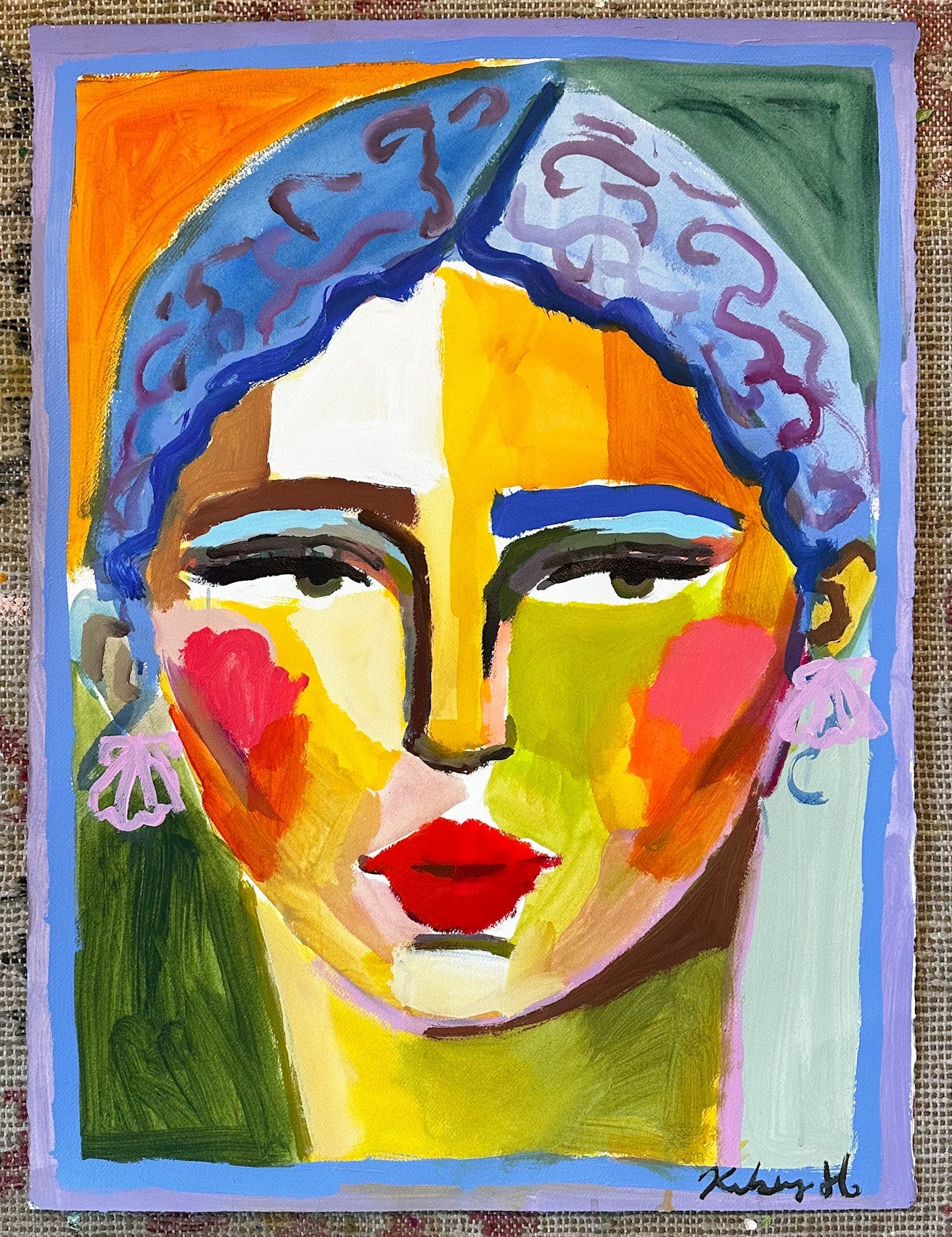 Colorful abstract painting of a face with blue hair on a textured fabric background