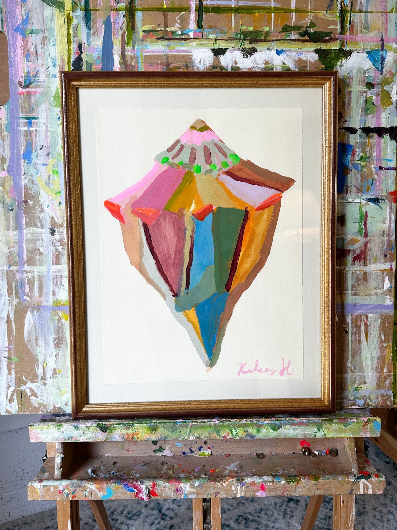 Colorful abstract painting on an easel with a textured wall background