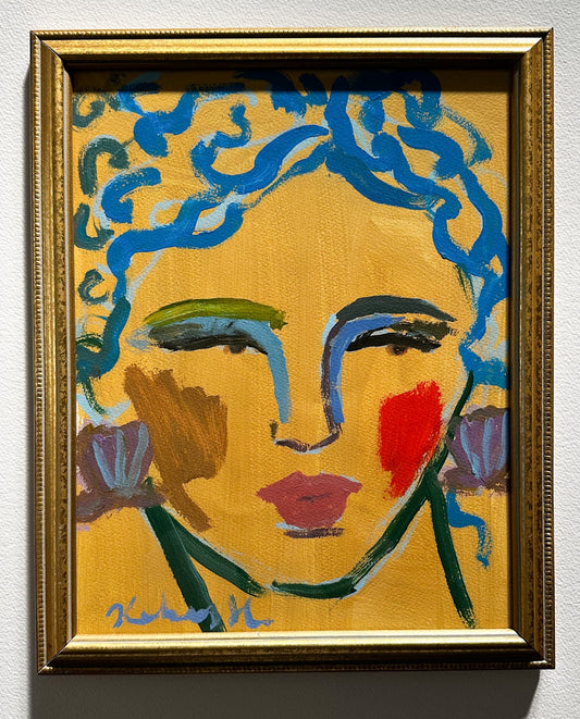 Framed artwork of a stylized face with blue hair and colorful makeup on a yellow background.