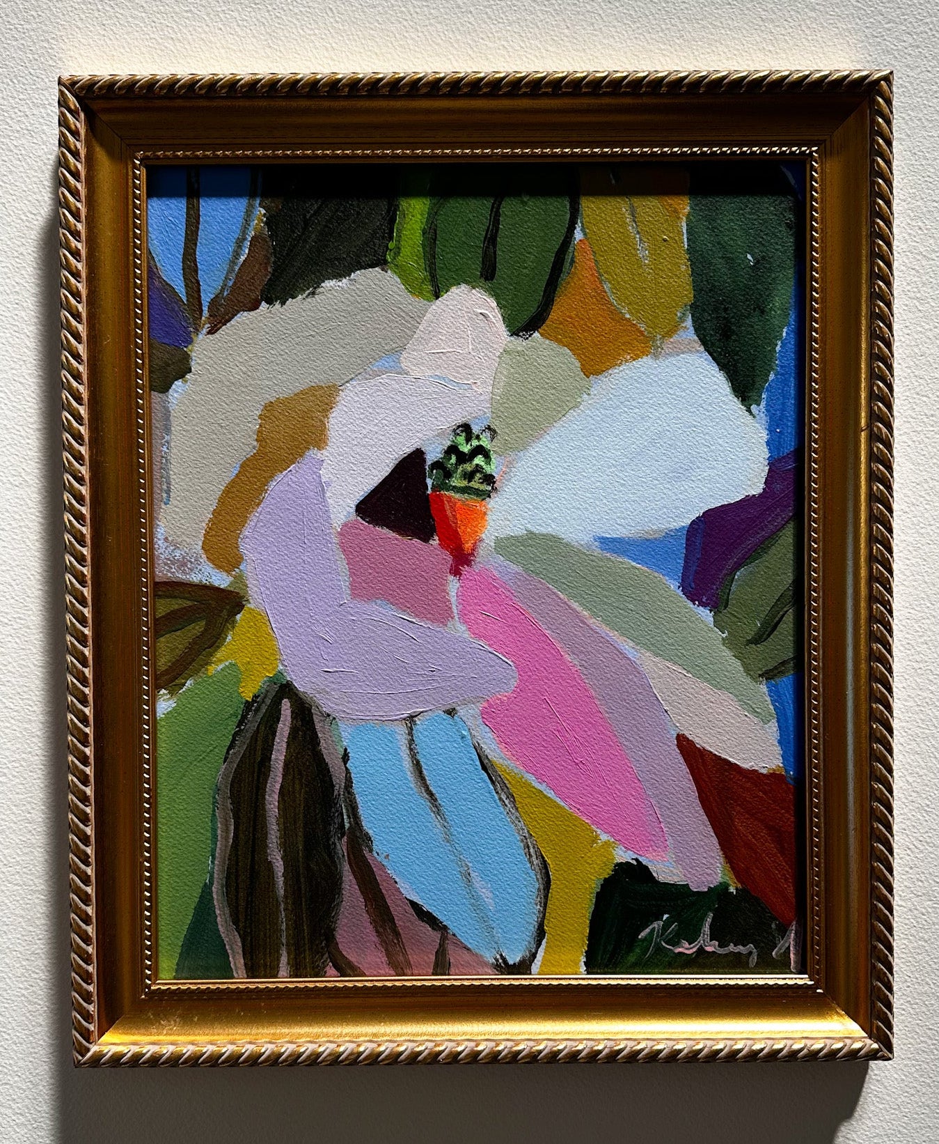 Framed abstract artwork with colorful flowers on a white wall