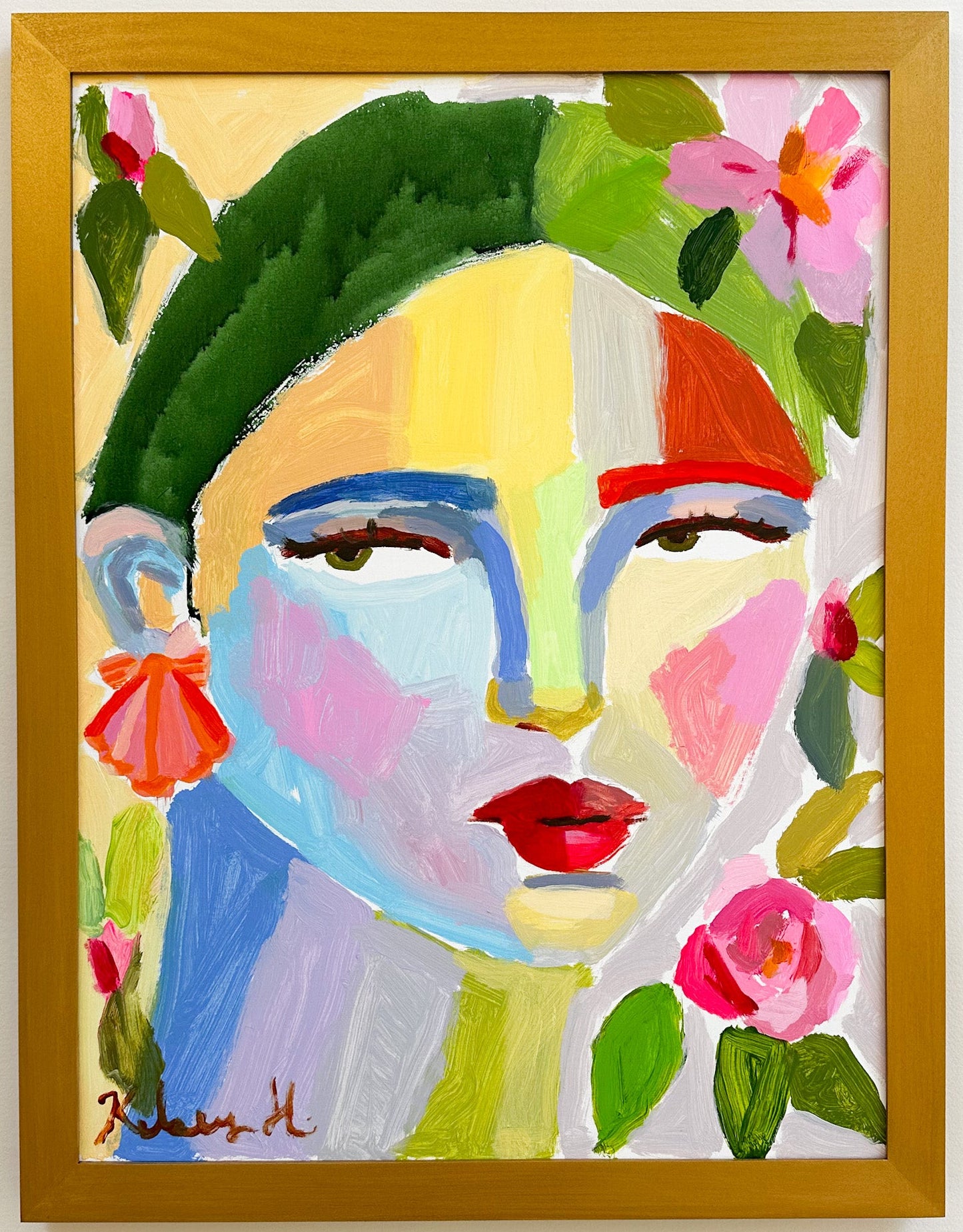 Colorful abstract painting of a face with flowers in a wooden frame.